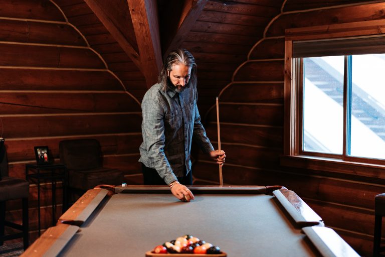 Garrett Gunderson thoughtfully playing pool, reflecting on business